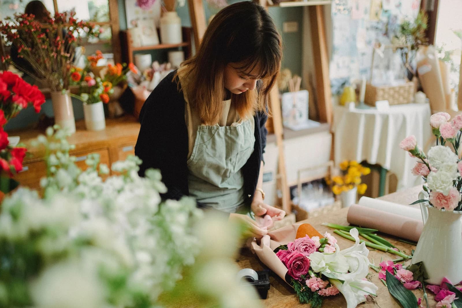Uma florista prepara um ramo na sua loja